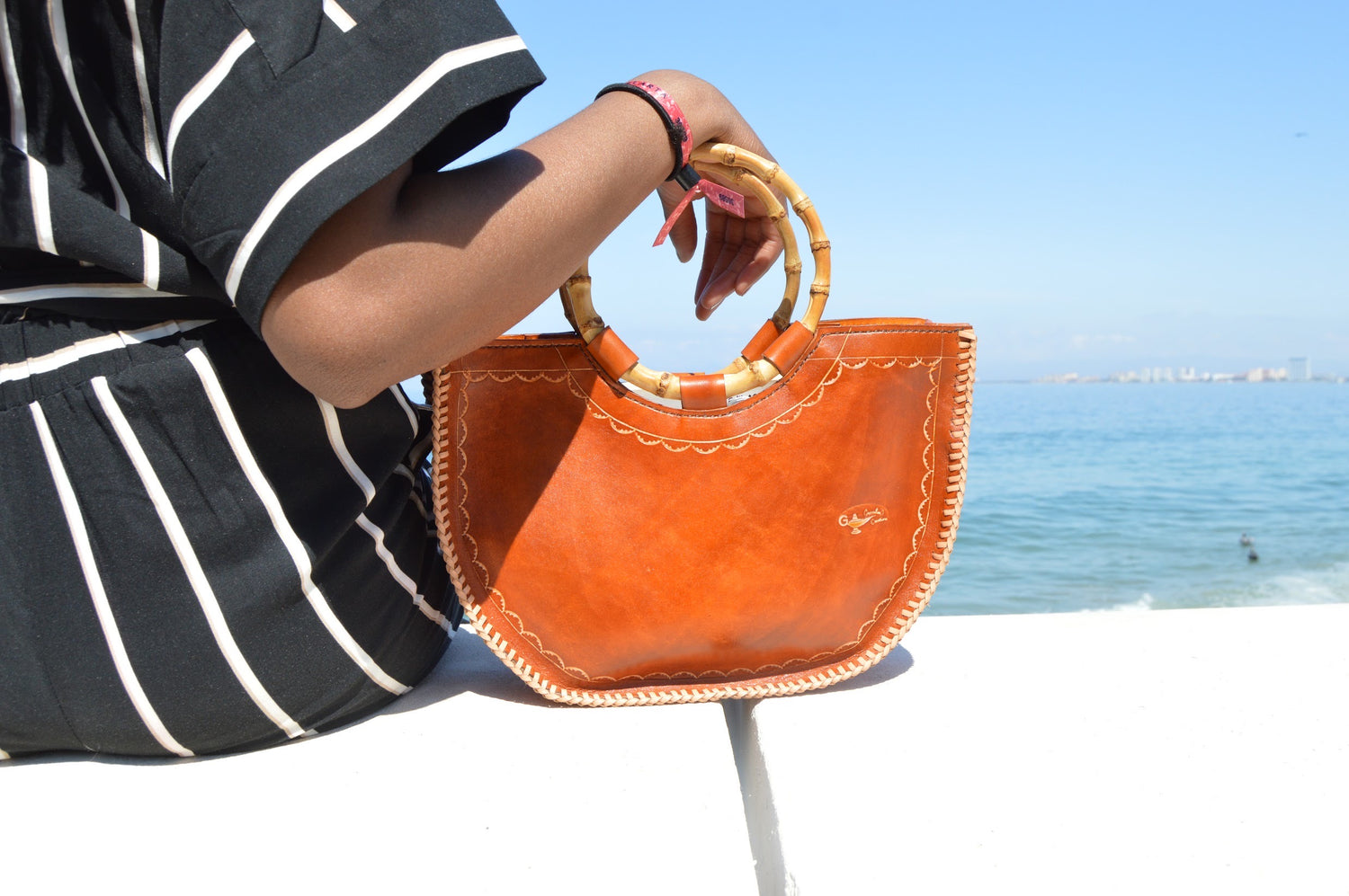 Girl with Orange leather bag on the sea side